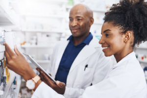 Shot of two pharmacists doing inventory in a pharmacy with a digital tablet
