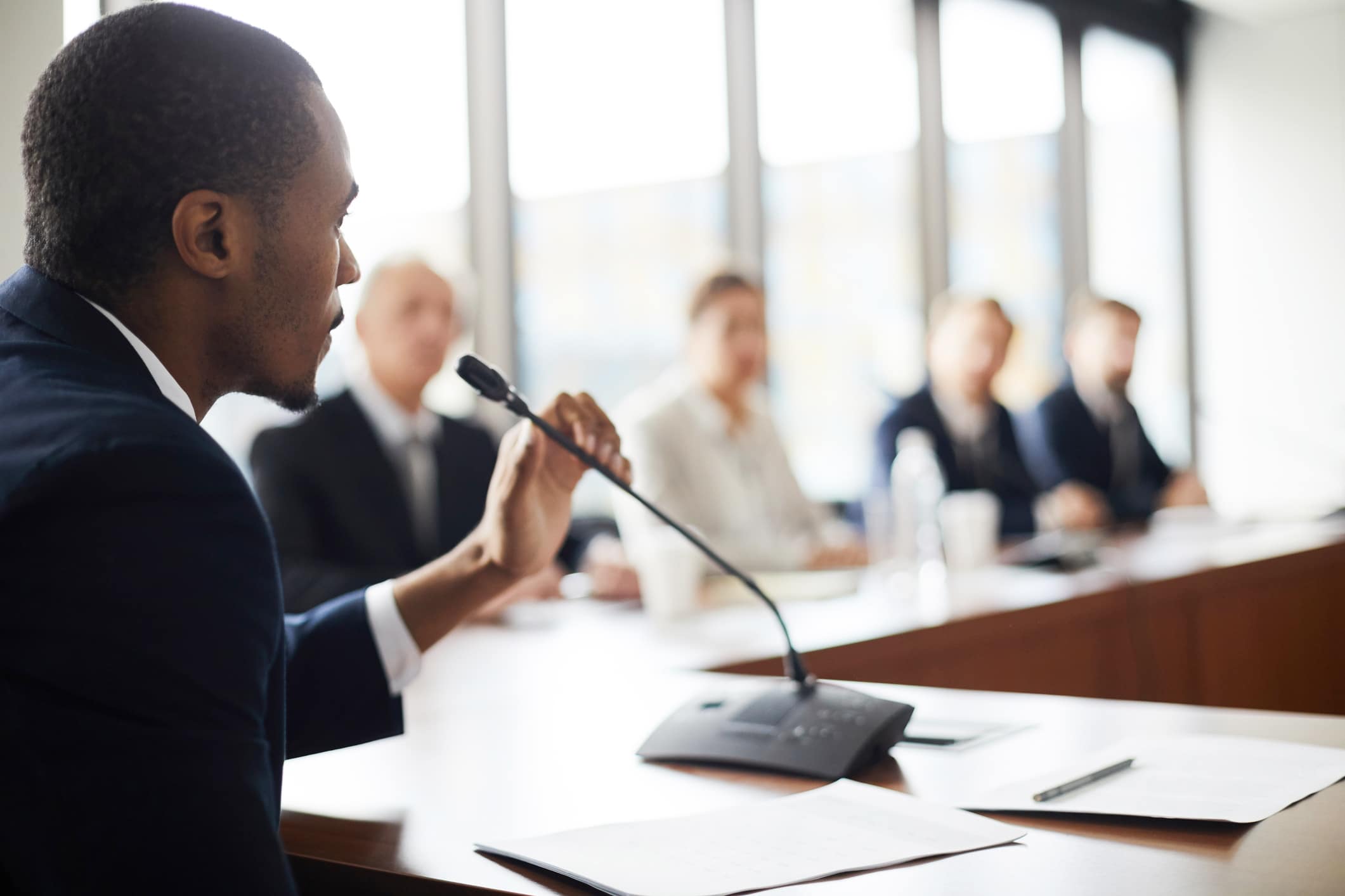 Man speaking to mic during a meeting