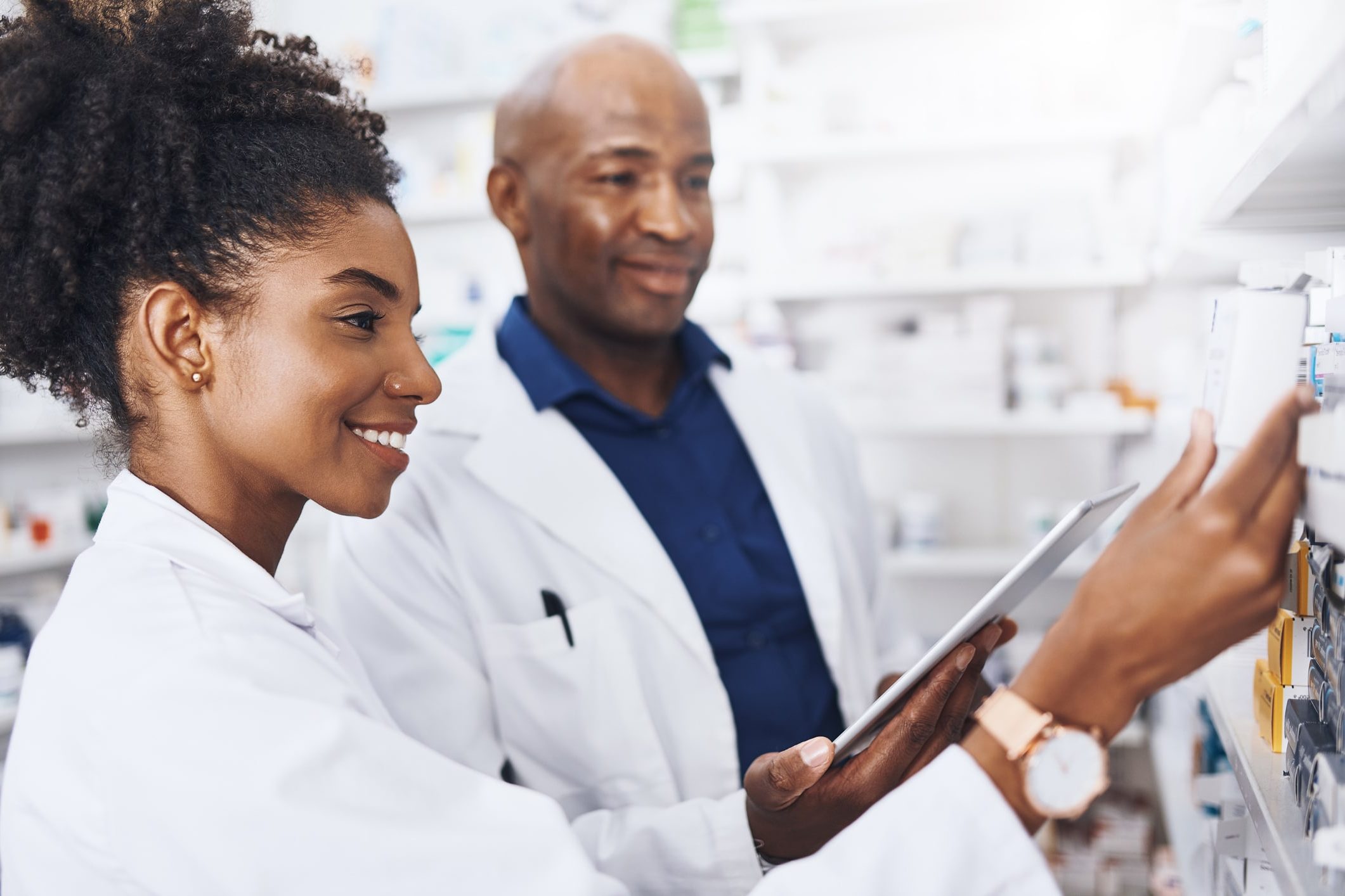 Shot of two pharmacists doing inventory in a pharmacy with a digital tablet