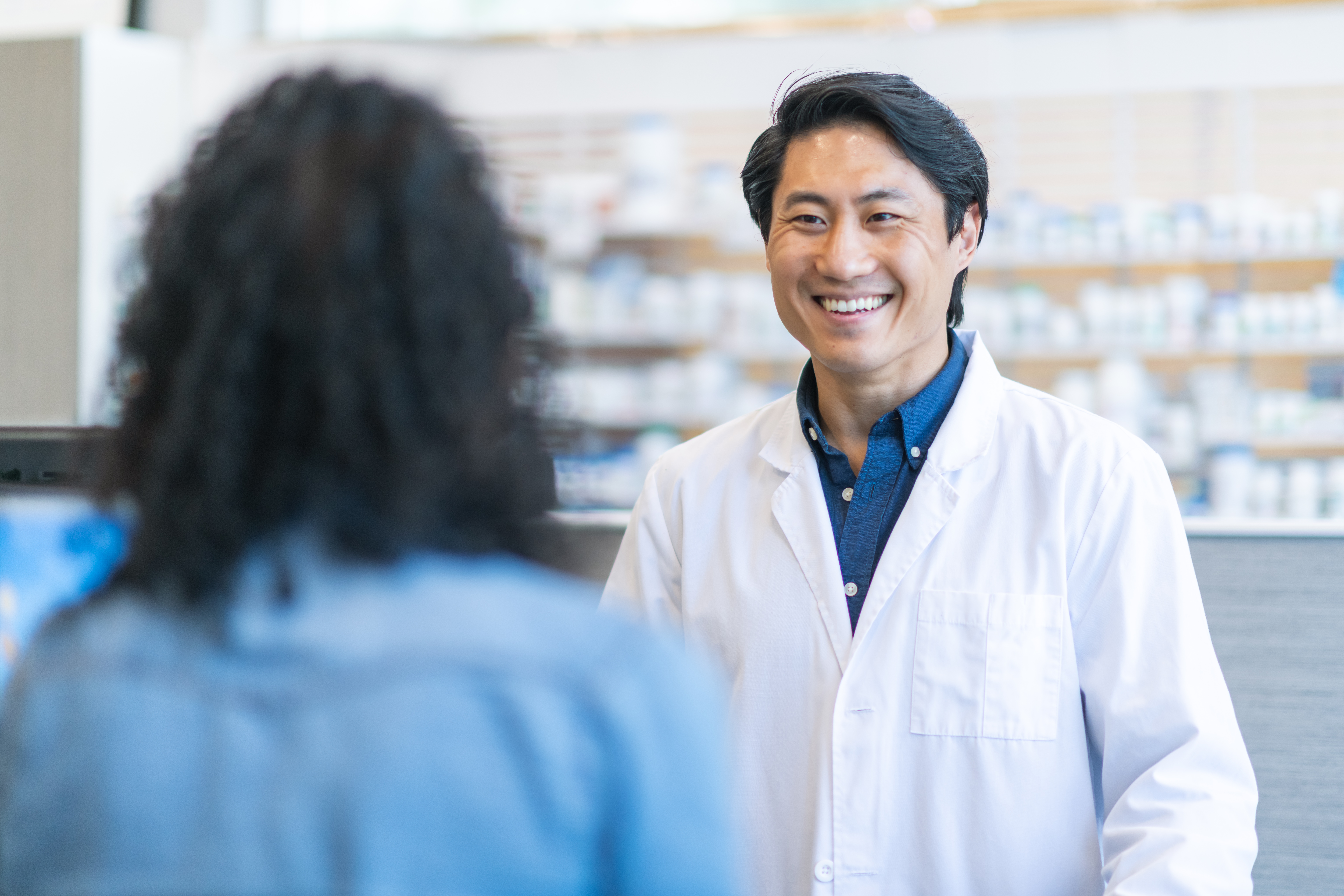 A pharmacist smiling at a client.